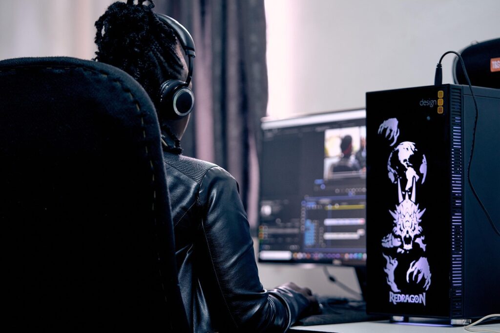 Person sits at desk and edits a video on a computer 